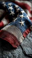Old American flag draped on textured stone surface, capturing the essence of patriotism and history photo
