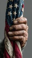 Old, weathered hands hold an American flag symbolizing resilience and patriotism in a somber moment photo