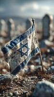 Worn Israeli flag stands among stones in a somber landscape, reflecting history and resilience under a cloudy sky photo