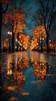 Colorful autumn leaves reflect in puddles on a quiet street illuminated by warm streetlights at dusk photo
