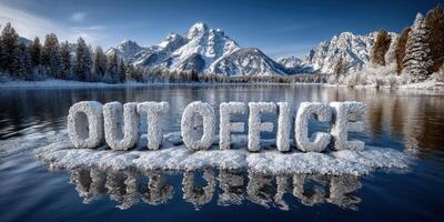 Snow-covered Out Office sign by a serene lake with majestic mountains in the background reflecting clear blue skies photo
