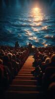 Audience watches a mesmerizing performance against a shimmering ocean backdrop at a coastal theater during sunset photo