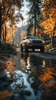 Autumn drive through forest with Toyota truck reflecting on water photo