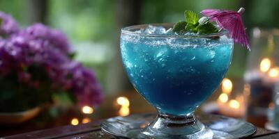 Refreshing tropical blue cocktail served at an outdoor lounge in the evening with floral decorations and soft lighting photo