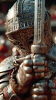 Warrior in detailed armor holds sword ready for battle at a medieval festival during a sunny afternoon photo