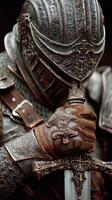 Intricate medieval armor with a knight holding a sword in a moment of reflection photo