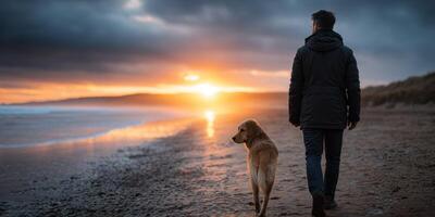Man and dog enjoy sunset stroll on the beach during a calm evening photo