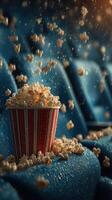 Popcorn spills over a bucket in a dimly lit movie theater during an exciting moment in the film photo
