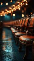 Rows of weathered wooden chairs illuminated by soft glowing lights, creating an inviting atmosphere in a cozy venue photo