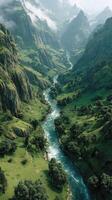 Majestic river flows through lush green valley under misty mountains in the early morning light photo