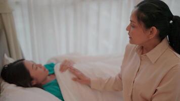 A mother lovingly caressing her daughter in bed. In this tender moment, a gentle touch conveys compassion and care, which in turn conveys support and comfort. video
