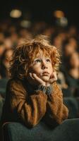Young boy in brown sweater watching performance with curiosity during crowded event photo