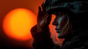 Soldier salutes the sunset while on duty at military base during evening hours photo