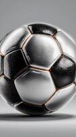 Soccer ball resting on a smooth surface showcasing its textured design and classic black and white pattern photo