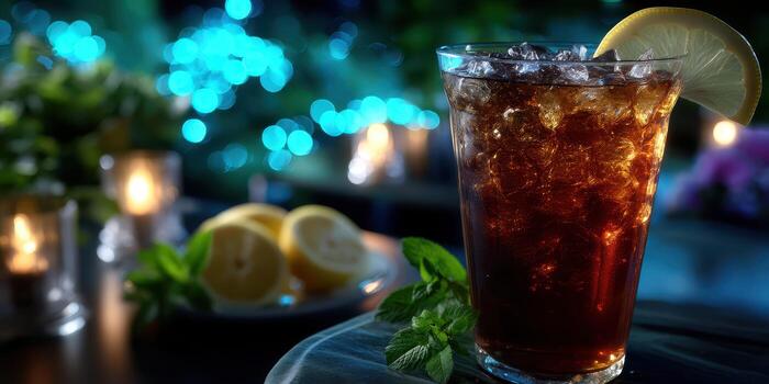 Refreshing iced beverage with lemon slice and mint leaves in a cozy setting during evening hours photo