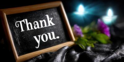 Elegant thank you message displayed on chalkboard with candles and flowers in a dimly lit setting photo