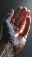 Close-up of an open hand against a dramatic light showcasing skin texture and detail photo