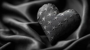 Decorative heart shape on dark fabric with star patterns creates an elegant display in soft, shadowy lighting photo