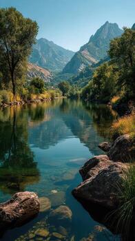 Scenic river view surrounded by mountains under clear blue sky in a tranquil natural setting photo