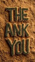 Creative gratitude message made of grass-like letters on sandy ground photo
