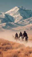 Riders on horseback traverse a dusty trail in the mountains during sunset in a remote landscape photo