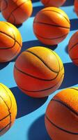 Bright orange basketballs scattered on a vibrant blue surface create a striking visual composition photo