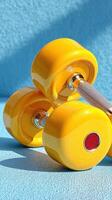 Bright yellow dumbbells resting on a textured blue surface during a fitness routine photo
