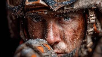 Soldier focused on mission while covered in dirt and debris during training exercise in harsh conditions photo