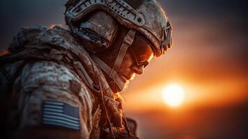 Soldier in silhouette watches sunset during military operation in desert environment photo