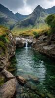 Serene mountain landscape featuring a tranquil river and cascading waterfall in a lush valley photo