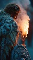 Warrior holding a flaming torch in a snowy landscape during a twilight battle preparation photo