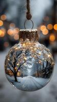 Winter holiday ornament reflects snowy street with twinkling lights in a charming village setting photo