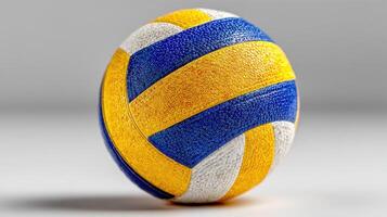 Vibrant yellow and blue volleyball resting on a grey background capturing the essence of sports and competition photo