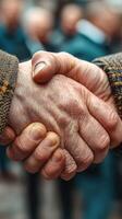 Hands meet in a firm handshake symbolizing friendship and unity during a gathering in a community setting photo