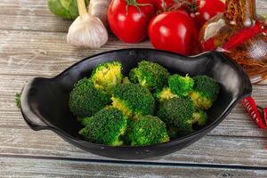 A bowl of broccoli with tomatoes and spices photo