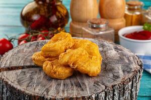 A pile of fried chicken on a wooden table photo