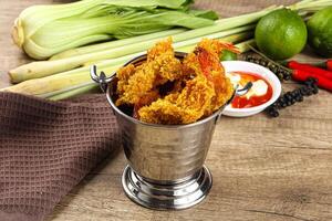 A silver bucket filled with fried shrimp and other vegetables photo