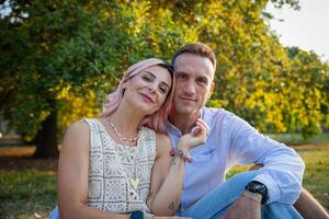 A loving couple sitting together in a park in the open air, partners enjoying their time together photo