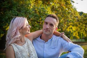 Beautiful loving couple embraced stand still during a walk in the park photo