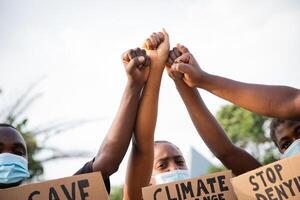 Close-up of the raised fists of a group of African guys protesting. photo