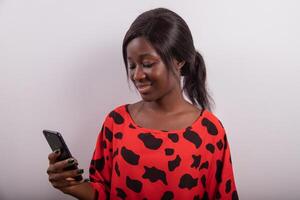 While taking a shot in the photo studio, the black girl looks at the messages on her smart phone