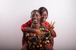 Girlfriend on the back of their boyfriend pose for a photo in the studio together, happy and in love couple.
