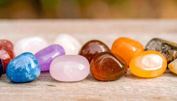 Close up of illuminated gemstones in vibrant hues on a polished dark surface with dazzling reflections photo