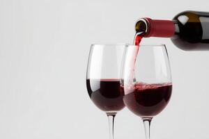 Red wine being poured into a wine glass on a gray background with area for text or design photo