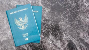 Yogyakarta, Indonesia, 2025 - Indonesian passport documents isolated on marble pattern background photo