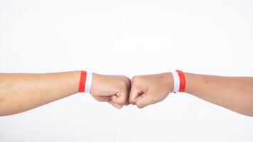 Two men with red and white wristband doing fist bump isolated on white background photo