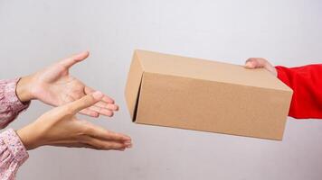 Close up of customer taking a package box parcel given by delivery man in red uniform isolated on white background photo