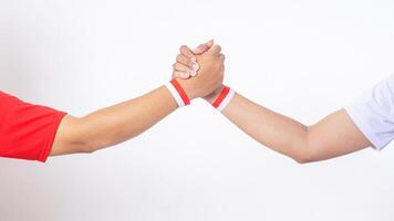 Two men hands with red and white wristband doing unity handshake isolated on white background photo