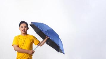 Smiling Asian man holding an umbrella isolated on white background photo