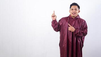 Asian man in red raincoat pointing at empty space for advertisement or copy space concept isolated on white background photo